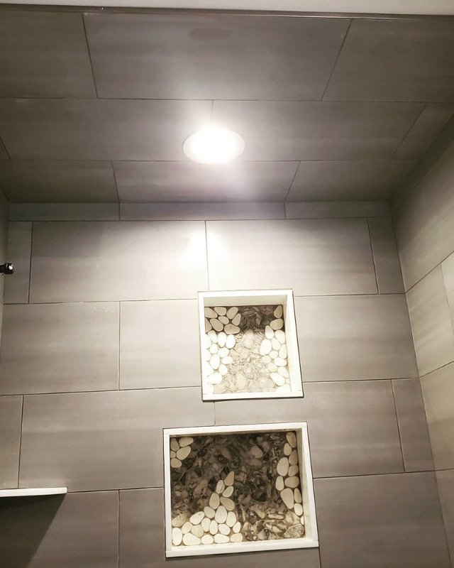 Picture of a custom tiled shower called Sahara Sand with pebble stone in the niche.